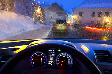 Car interior and illuminated street view. Dashboard, speedometer