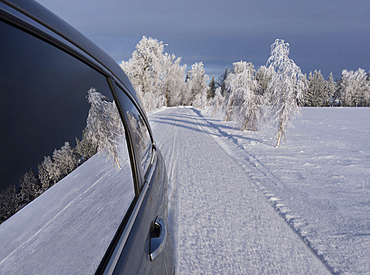 Car with closed windows parked on a snowy road.