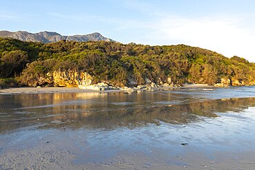 Woodland and mountains scenery, a small sheltered sandy beach on the Atlantic shore, Grotto Beach, Western Cape, South Africa