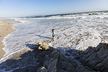 Young boy playing in surf on a sandy beach, Grotto Beach, Western Cape, South Africa