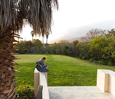 Teenage girl playing guitar and singing outdoors, Stanford, Western Cape, South Africa