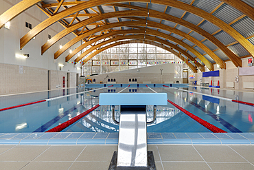 Indoor swimming pool, starting block, diving block and marked lanes, flat calm water