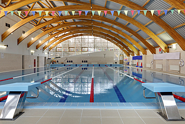 Indoor swimming pool, starting block, diving block and marked lanes, flat calm water