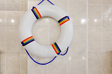 Life preserver, life ring on a wall in an indoor swimming pool.