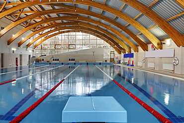 Indoor swimming pool with marked lanes, flat calm water and diving block