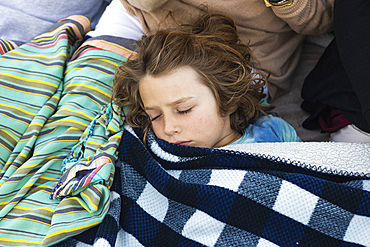 Young boy resting under blanket, De Kelders, Western Cape, South Africa.