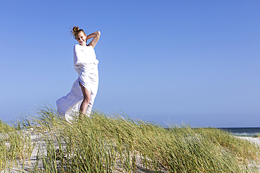 Teenage girl wrapped in white, Grotto Beach, Hermanus, Western Cape, South Africa.