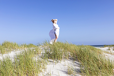 Teenage girl wrapped in white, Grotto Beach, Hermanus, Western Cape, South Africa.