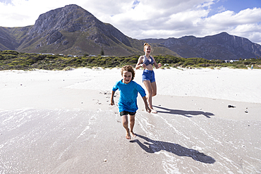 Children playing in surf, Grotto Beach, Hermanus, Western Cape, South Africa.