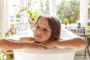 Eight year old boy in the bathtub, head and shoulders.