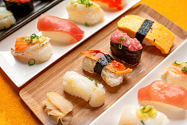 Sushi platter, a selection of raw fish and rice snacks with chopsticks.