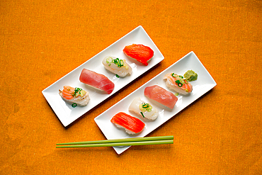 Sushi platter, a selection of raw fish and rice snacks with chopsticks.