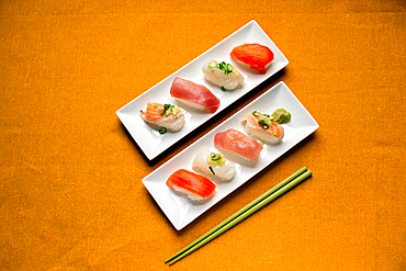 Sushi platter, a selection of raw fish and rice snacks with chopsticks.