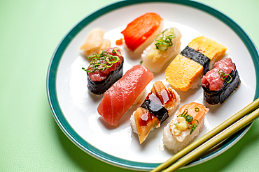 Sushi platter, a selection of raw fish and rice snacks with chopsticks.