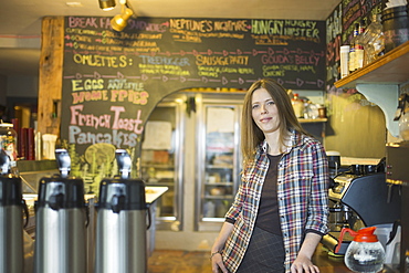 A coffee shop and cafe in High Falls called The Last Bite. A woman leaning on the counter, by the coffee machine, New York, USA