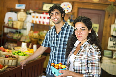 A farm growing and selling organic vegetables and fruit. A man and woman working together, Hurley, New York, USA