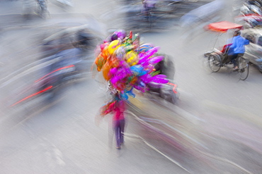 A busy street in Hanoi city, with motorscooter traffic and people with colourful balloons, Hanoi, Vietnam