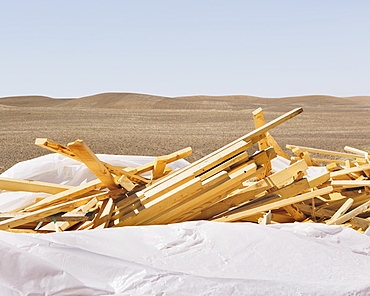 White tarp covering pile of wood 2x4 studs, farmland in background, near Pullman, Pullman, Washington, USA