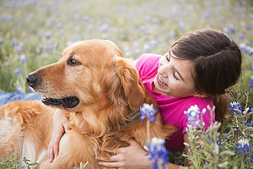 A young girl hugging a golden retriever pet, Girl, Texas, USA