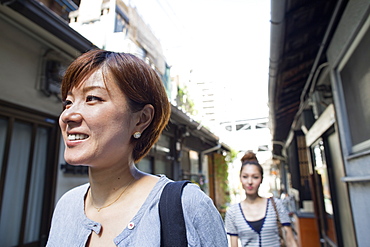 Two women standing outdoors, smiling, Osaka, Japan