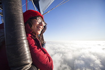 Woman travelling in a hot air balloon, Monmouthshire, Wales