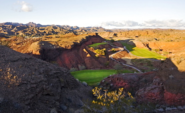 An elevated view over the mountain and desert landscape and golf course greens in the valley, Desert golf course, Arizona, USA