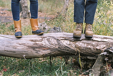 Close up of couple standing side by side on a tree trunk, Millcreek, Utah, United States of America