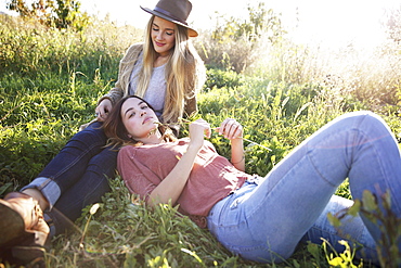 An apple orchard in Utah. Two women lying in the grass, Sataquin, Utah, United States of America