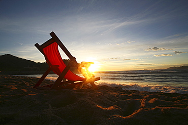 A chair on the sand facing the water, Barra de Navidad, Mexico