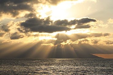 Sunset over the ocean, shafts of sunlight falling to the water, and layers of clouds, Mexico