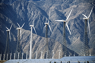 Wind power turbines in the landscape. A large number of turbine powers on a plain against a mountain backdrop, United States of America