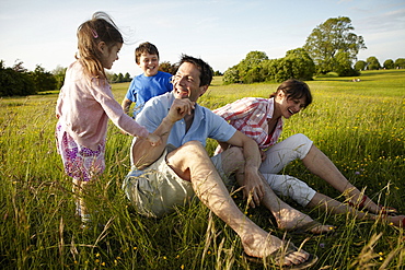 A family, two parents and two children outdoors on a summer evening, England, United Kingdom