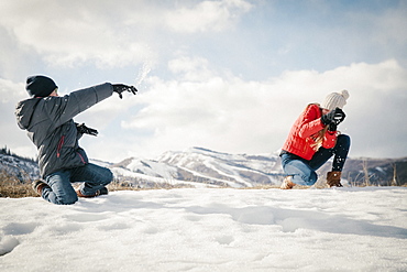 A snowball fight between a brother and sister, Mountains, Utah, USA