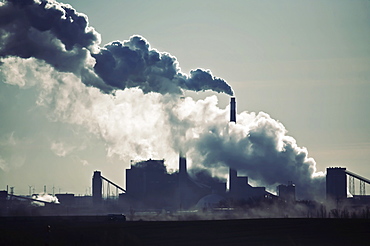 Heat, steam and smoke rising from the chimneys of a power plant against the sky, Power Plant, USA