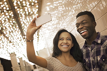 A man and woman in a brightly lit space, a casino entrance, taking a selfy with a smart phone, United States of America