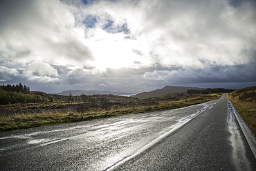 An empty two lane road through a deserted landscape, reaching into the distance. Low cloud in the sky, Scotland, United Kingdom