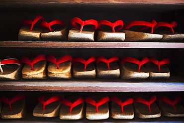 Rows of traditional wooden sandals with thick soles and red straps worn by geisha, okobo or geta, Japan