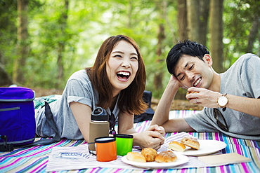 Young woman and man having a picnic in a forest, Japan