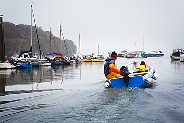 Sailing boats and motorboats moored in the Fal estuary, A fisherman in a small boat, Fal Estuary, Cornwall, England