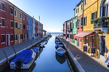 Small motorboats moored in narrow canal lines with colourful houses, Venice, Italy, Venice, Italy