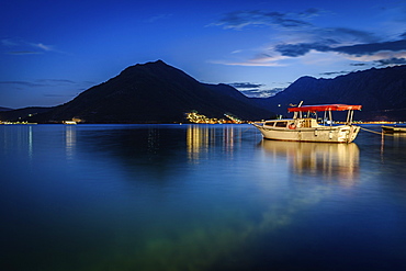 Boat moored in harbour of Perast in the Bay of Kotor, Montenegro at night, mountain in the distance, Perast, Bay of Kotor, Montenegro