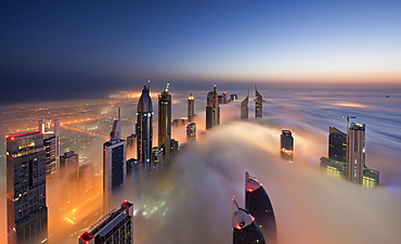 View of illuminated skyscrapers above the clouds in Dubai, United Arab Emirates at dusk, Dubai, United Arab Emirates