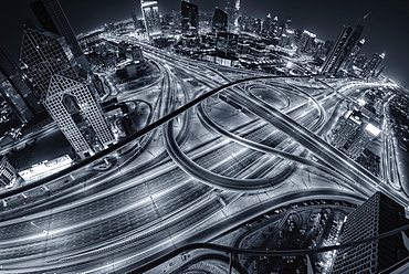 Aerial view of Dubai, United Arab Emirates at dusk, with illuminated highways in the foreground, Dubai, United Arab Emirates