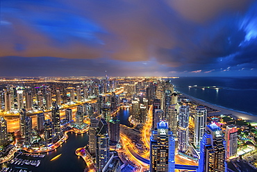 Cityscape of the Dubai, United Arab Emirates at dusk, with illuminated skyscrapers and coastline of the Persian Gulf, Dubai, United Arab Emirates