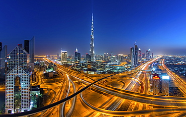 Cityscape of Dubai, United Arab Emirates at dusk, with the Burj Khalifa skyscraper and illuminated highways in the foreground, Dubai, United Arab Emirates