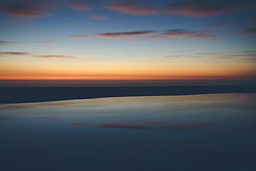 Seascape with cloudy sky at sunset.