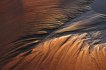 High angle close up of patterns in beach sand at dusk.