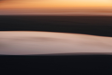 Landscape with ocean and beach at dusk.