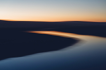 The open spaces of marshland and water channels. Flat calm water.  Dusk.