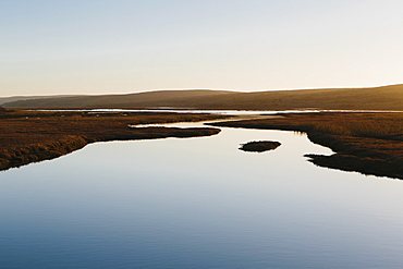 The open spaces of marshland and water channels. Flat calm water.